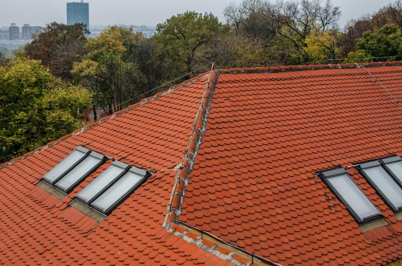 Terracotta clay tile roof with multiple skylights and roofline peaks