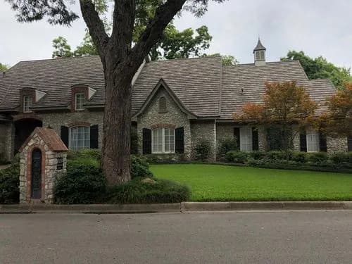 Classic Fort Worth stone manor home with cedar wood shake roof - City Roofing Company