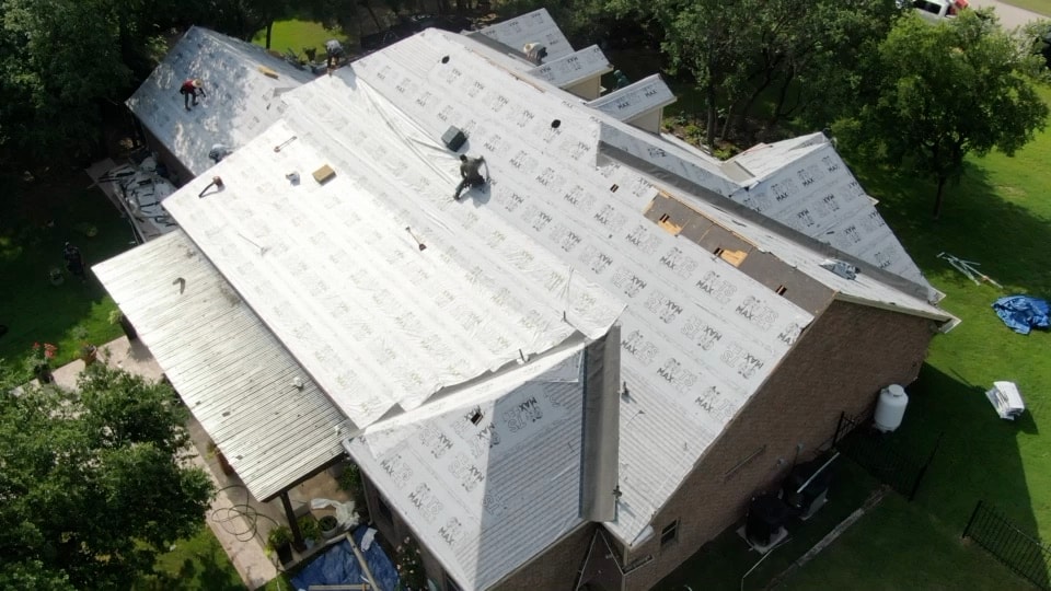Aerial view of a City Roofing crew installing roof underlayment in Fort Worth