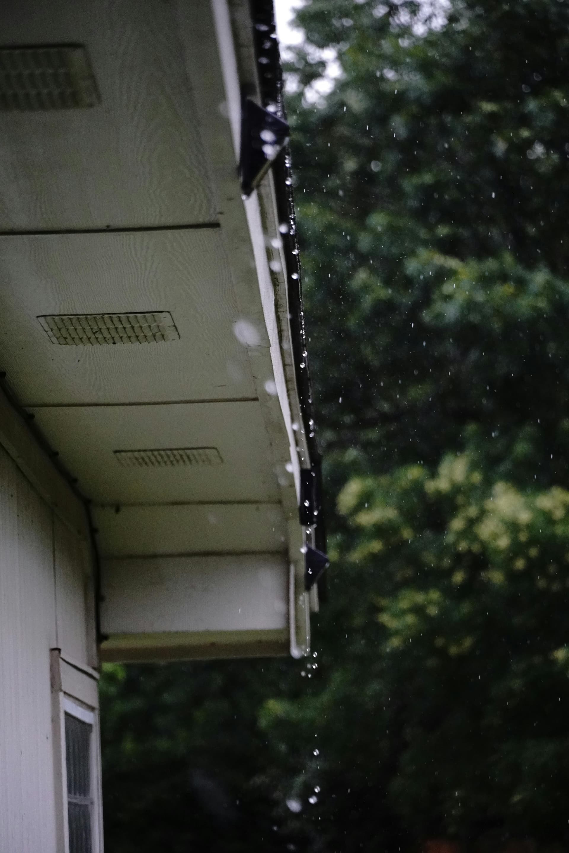Rain overflowing from a damaged gutter during a storm - demonstrating why gutter repair matters